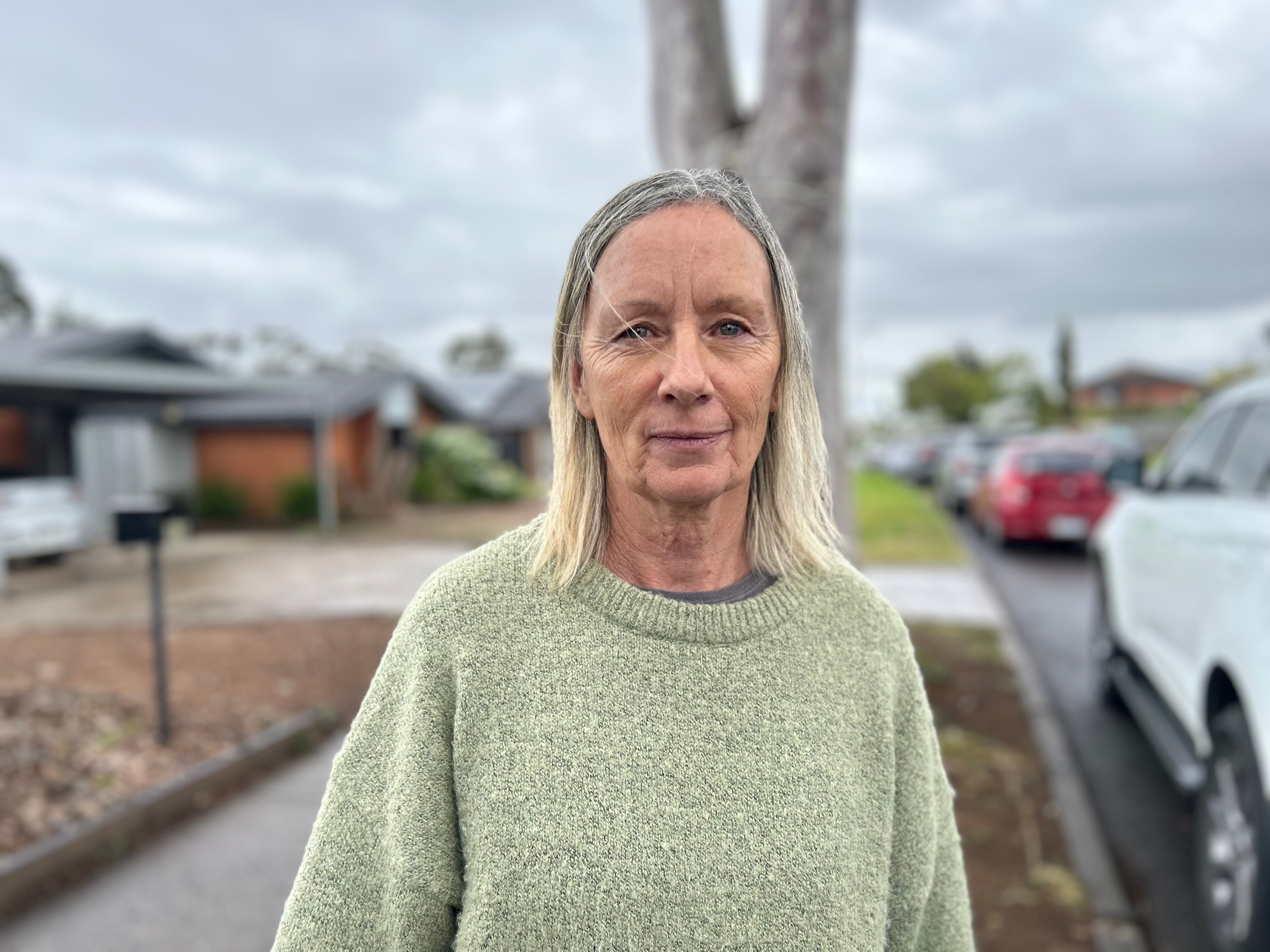 A woman looks at the camera seriously.