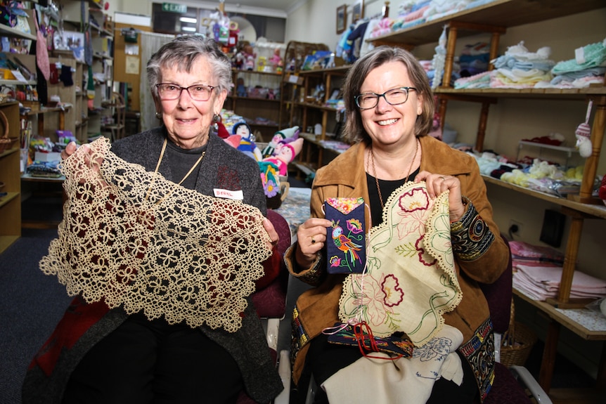 A mother daughter team demonstrate their craft handy work.