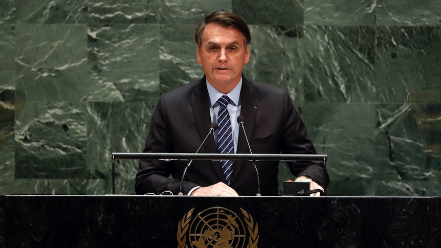 Jair Bolsonaro in a suit behind a podium at the UN General Assembly