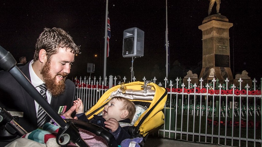 A man with a baby in a pram at the Kalgoorlie dawn service.