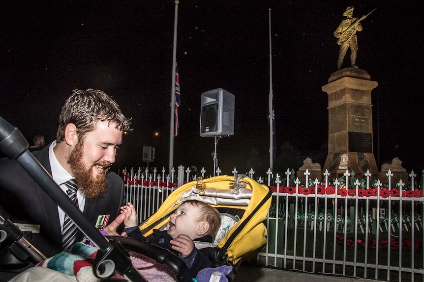 A man with a baby in a pram at the Kalgoorlie dawn service.