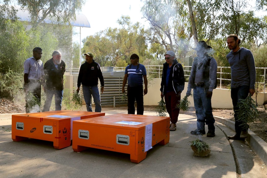 A smoking ceremony is held to cleanse cases containing sacred objects that are being returned to Aboriginal people.