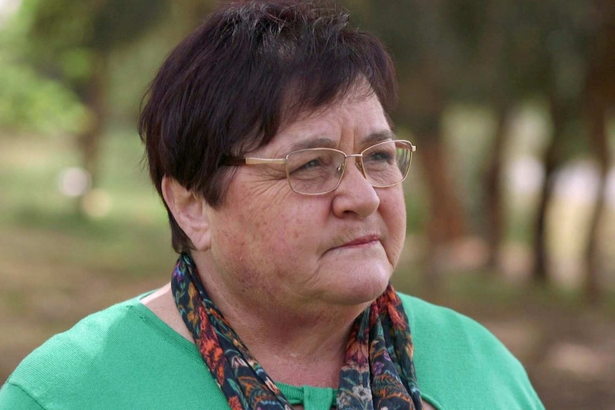 Jenny Hawthorne wears a green top, a scarf and spectacles