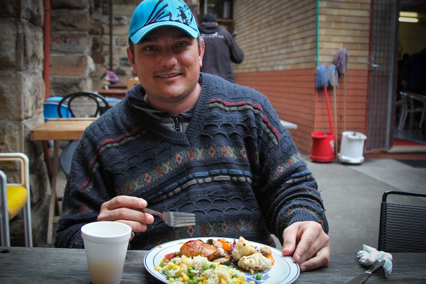 A man sitting with a plate of food.