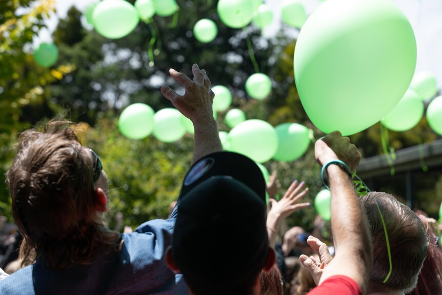 People release green balloons 