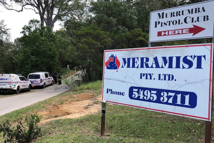 A police ute and a police van stationed on a the side of a driveway. A sign in the foreground reads "meramist".