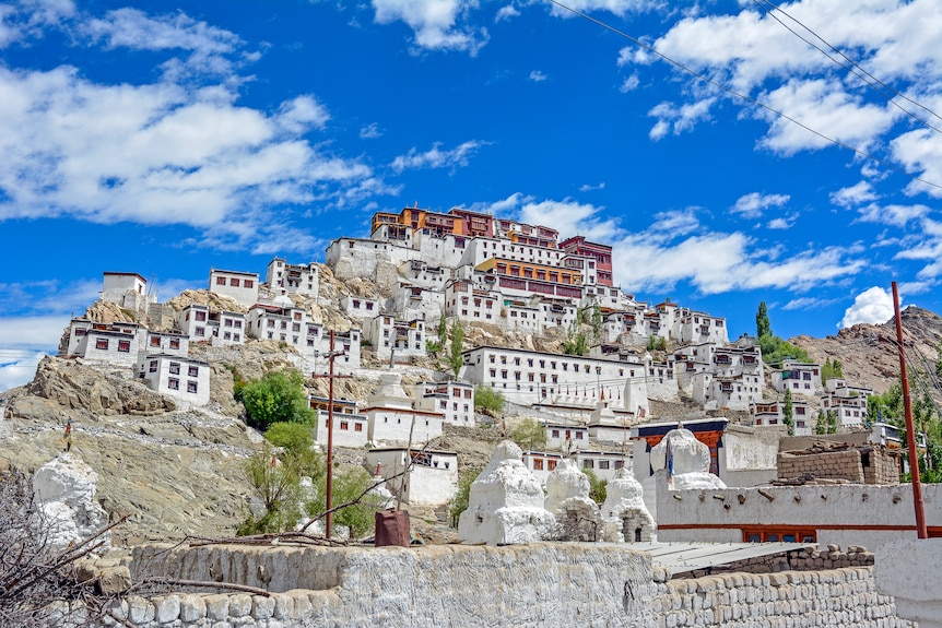 A row of white buildings stacked one on top of the other under a bright blue sky.