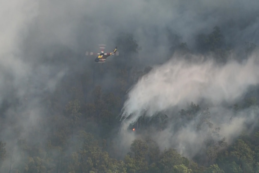 A helicopter surrounded by thick smoke