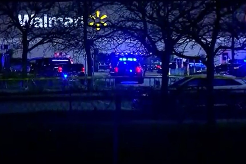 Screenshot of AP footage of Walmart where multiple people were shot dead. neon walmart sign and police cars
