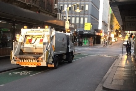 A waste truck on a street in a city in Melbourne.