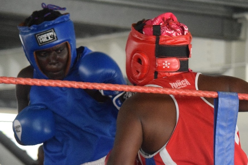 Two female boxers from Papua New Guinea exchange blows during a fight.