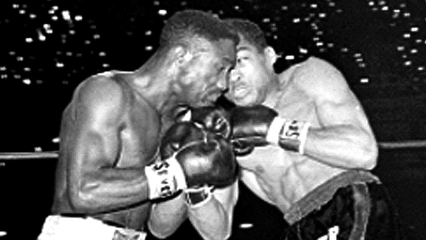 Two men boxing in a black and white photo.