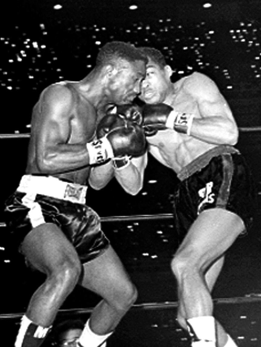 Two men boxing in a black and white photo.