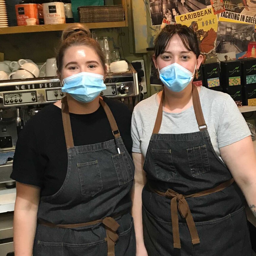 Mia and Danielle staff at the Warragul Plaza Cafe wearing masks next to coffee machine