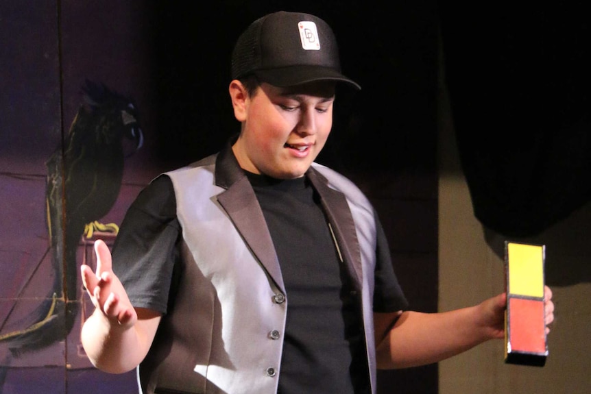 A man displays a top hat and some blocks a table