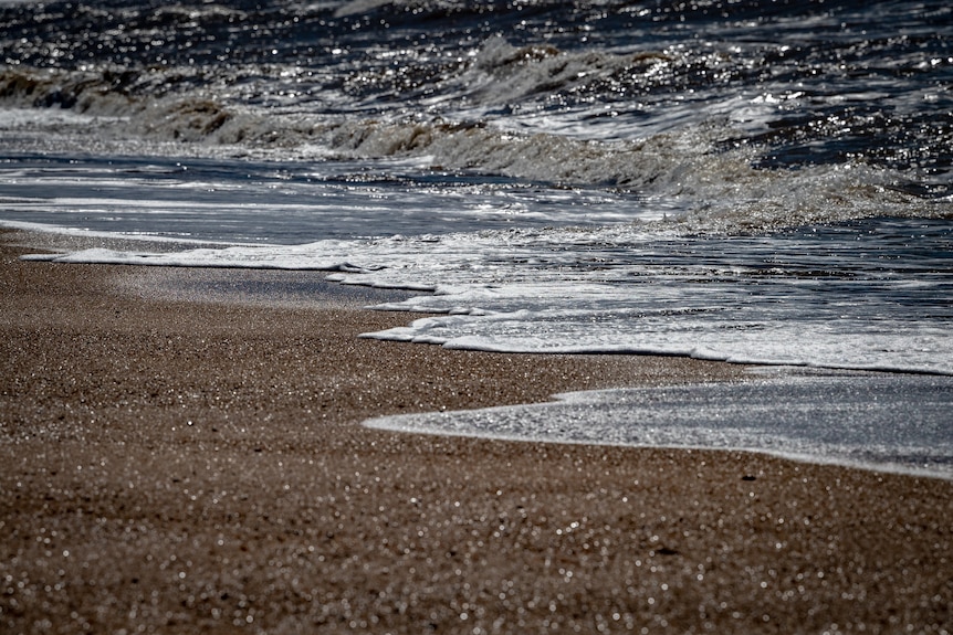 Ocean water lapping sand.