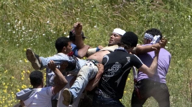 Demonstrators carry a wounded fellow protester who was hit by fire from Israeli forces