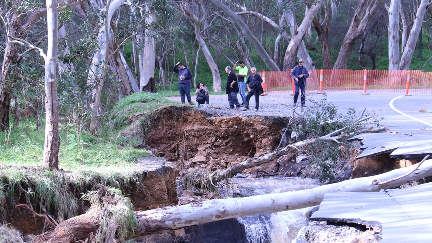 People gather around flood damaged Montacute Road.