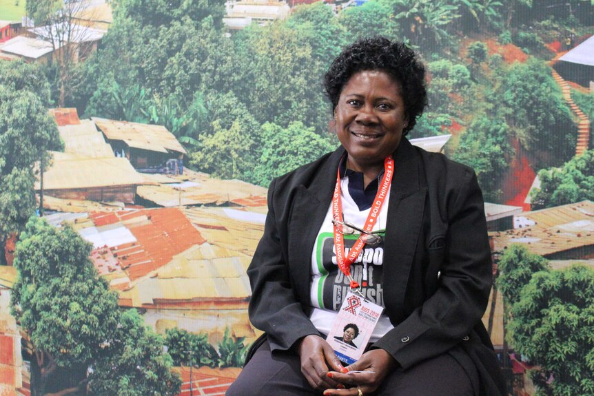 Rosemary Namubiru photographed against a background showing the roofs of houses.