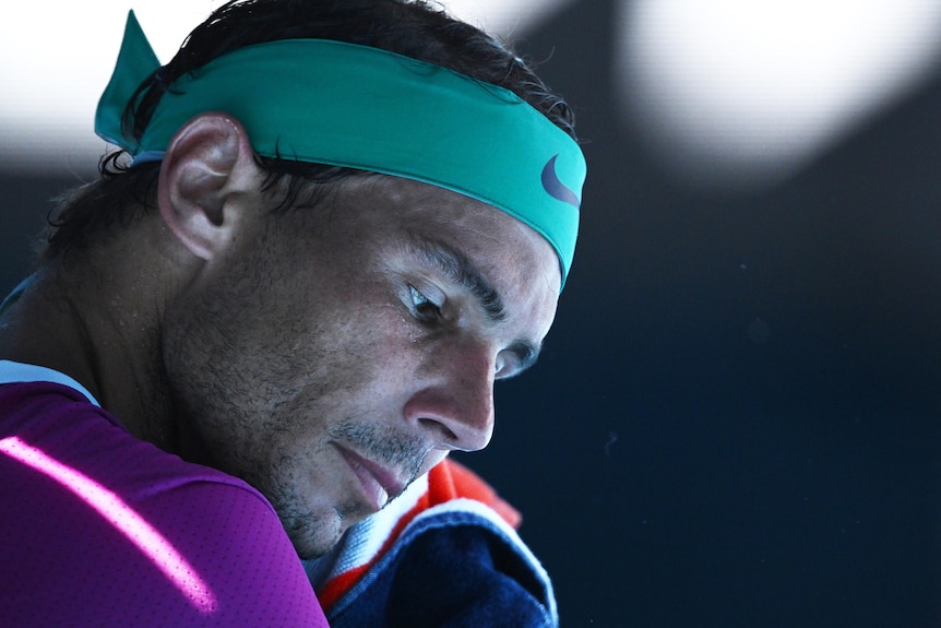 A Spanish male tennis player looks down at a change of ends at the Australian Open.