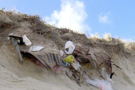 Rubbish from the decommissioned Port Fairy tip emerges through the dunes