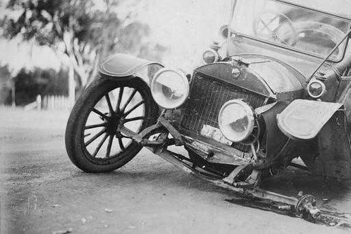 An old photo of a crashed car.