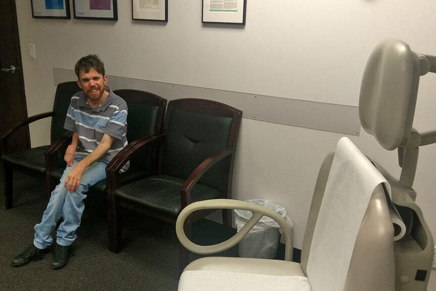 Jeremy Haines sits in the treatment room of Florida’s Institute of Neurological Recovery looking at the treatment chair.