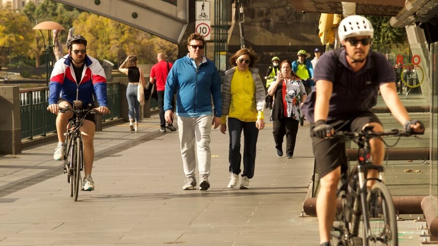 Pedestrians and cyclists move along the path outside Southgate, along the Yarra River just south of Melbourne's CBD.