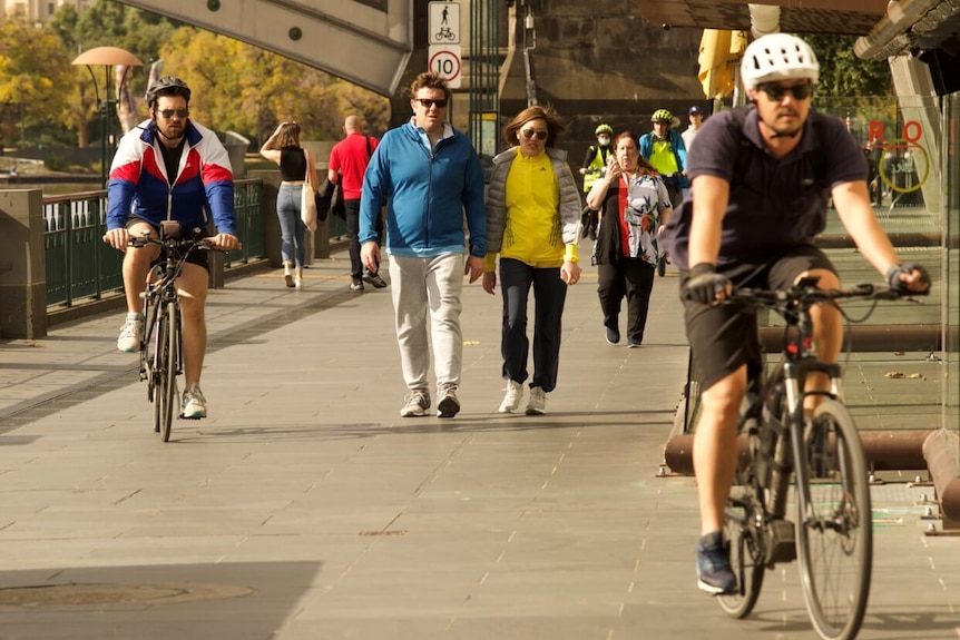 Pedestrians and cyclists move along the path outside Southgate, along the Yarra River just south of Melbourne's CBD.