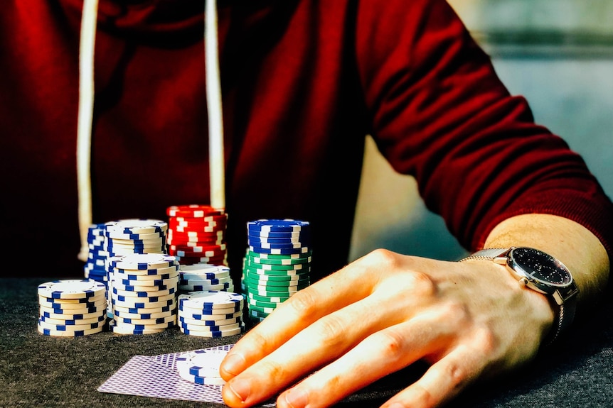 Gambling chips and cards behind a male hand