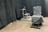 a firing squad chair and an electric chair are shown in a row with black curtains draped along the walls