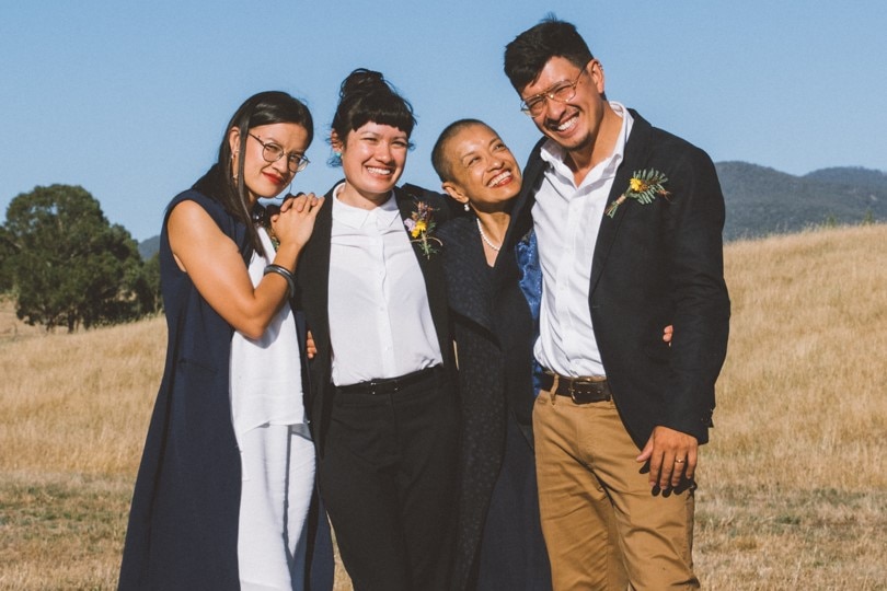 Three women and a man stand together smiling in a paddock for a story on griff anniversaries