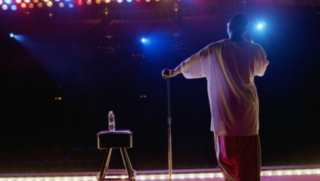 Comedian standing on stage, rear view