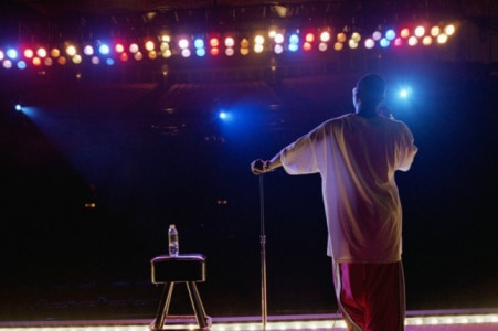 Comedian standing on stage, rear view