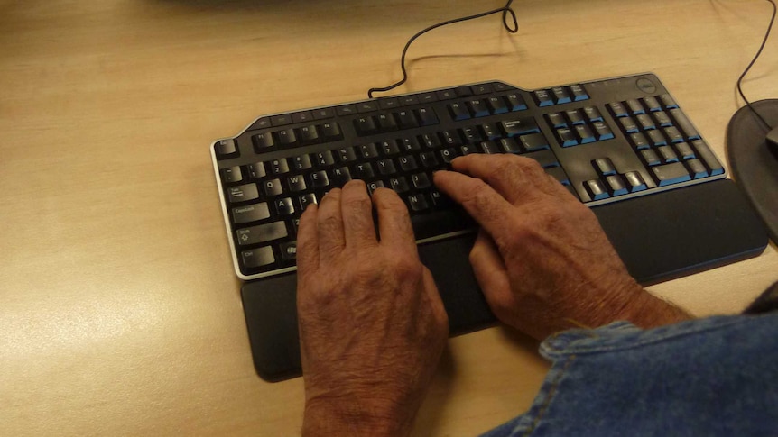 Man's hands on computer with screen blurry