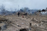 debris can be seen on the ground in a residential area after a military strike