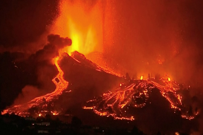 Lava flows out of a volcano at night