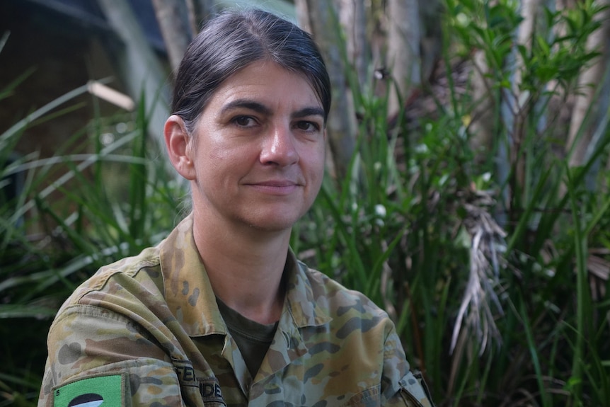 Susana Fernandez in uniform sitting in front of plants outside