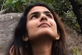 A woman with long dark hair staring up