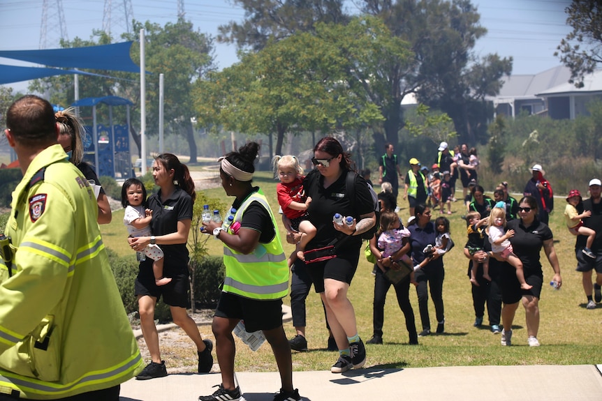 Children and staff walking through a park as they are evacuated