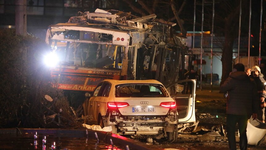 A man stands next to a burnt out bus after a blast in Ankara.