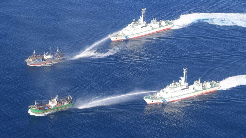 Japan Coast Guard warns a ship that has entered Japan's waters using a large water spray.