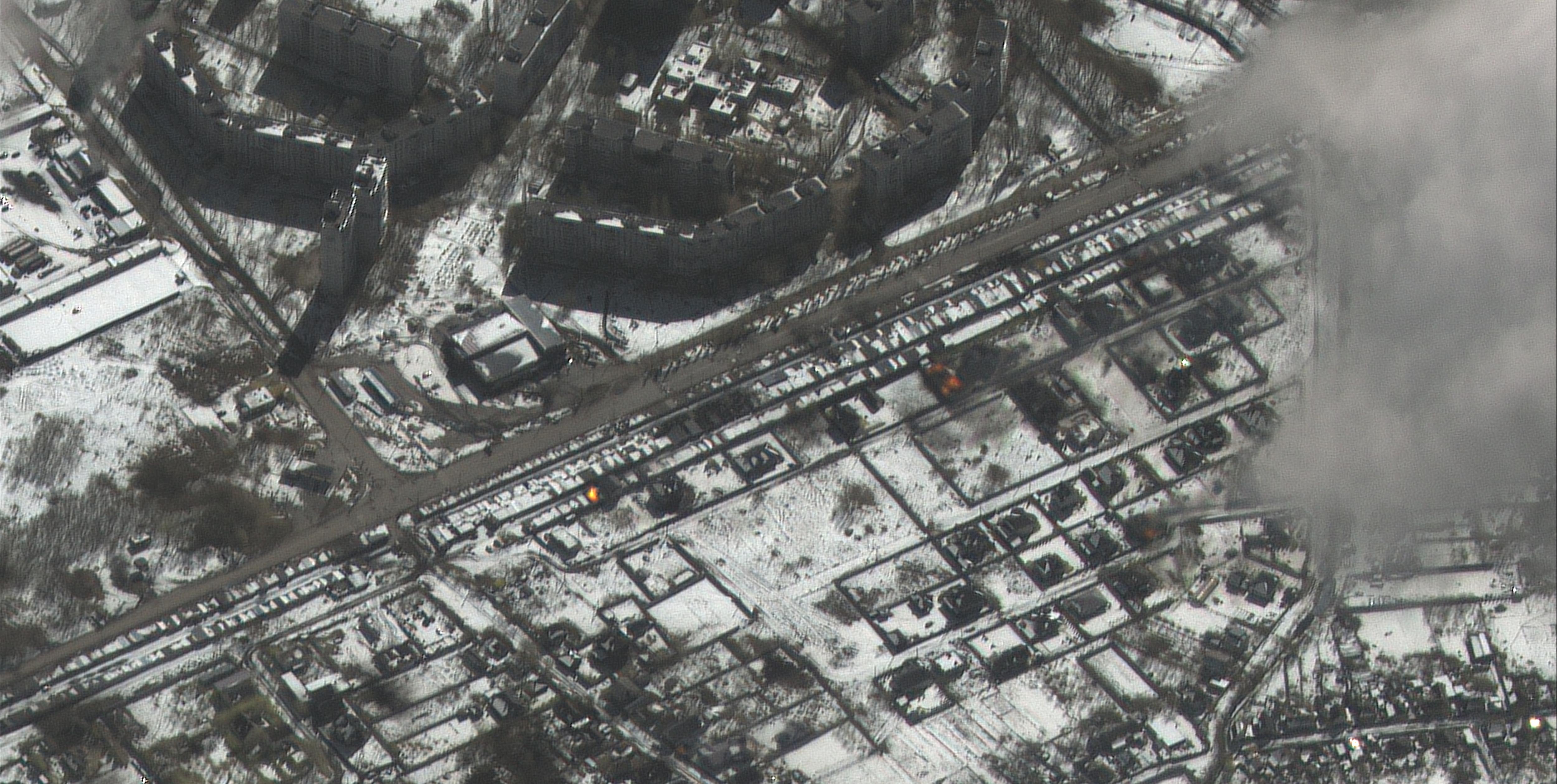 Black and white aerial image reveals city damaged by shelling. 