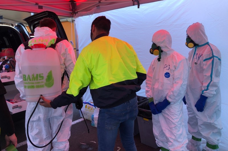 A group of people in hazmat suits and high-vis.