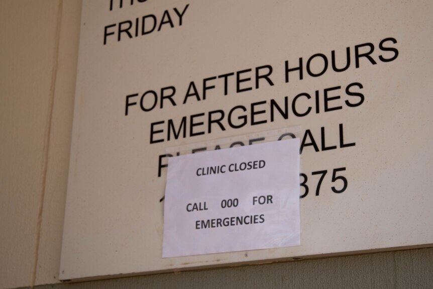A sign on a wall saying the clinic's closed.