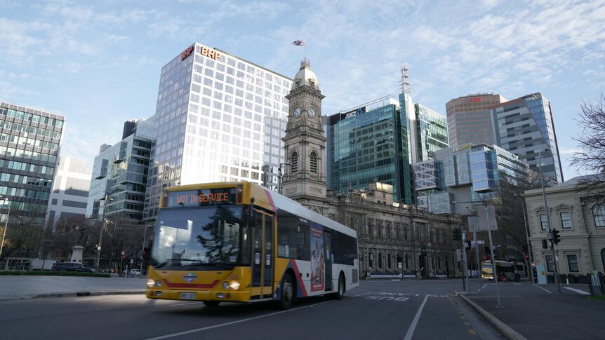 A bus on a city street with buildings behind