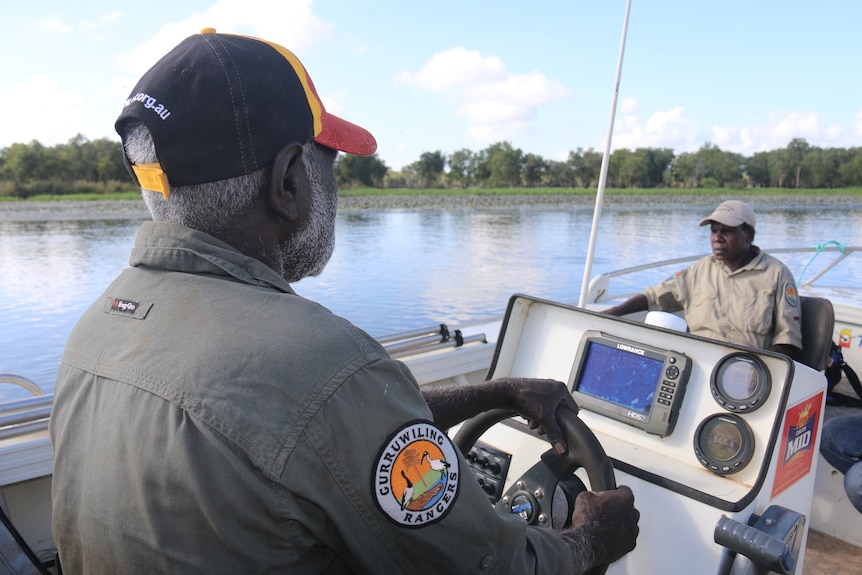 Rangers in a boat on the water.