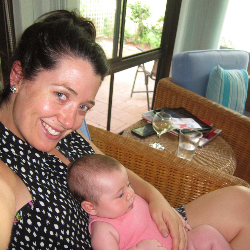 A woman holds a six-week-old baby while taking a selfie.