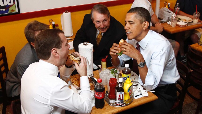 Russia's former president Dmitry Medvedev (L) and Mr Obama go to a burger joint.