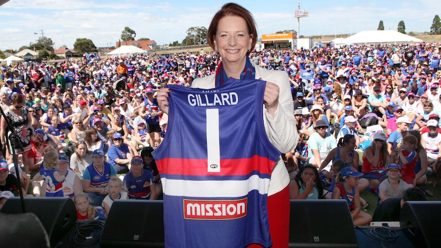 Julia Gillard holds up her Western Bulldogs AFL jersey